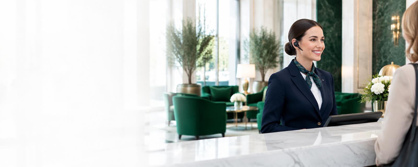 Hotel concierge wearing a wireless headset at a bright reception desk